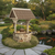 Amish handcrafted stone and poly wishing well, size jumbo, birchwood frame with brazilian walnut, brown stone with tan grout, brown shakes. Pictured beside a koi pond.