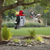 Amish made wooden bird shaped birdhouse in woodpecker design, pictured suspended over rock garden