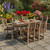 Amish crafted poly outdoor dining set, in birchwood and brazilian walnut, pictured on a patio by a flower garden.