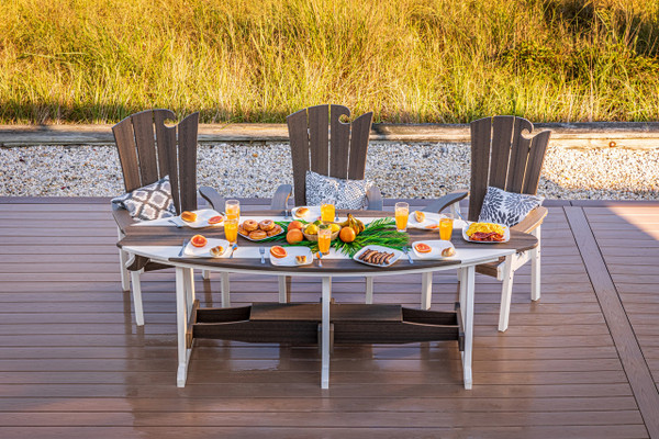 Surf-Aira 8 foot poly dining table and Ocean Wavz chairs finished in brazilian walnut and white, pictured on a seaside deck.