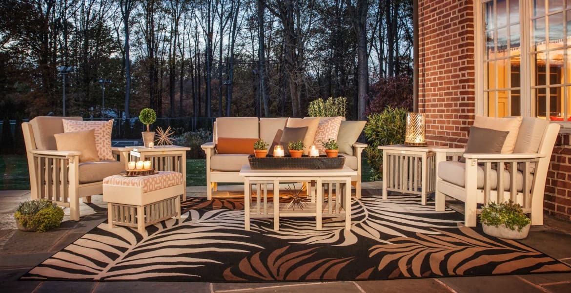 Amish made poly outdoor chair, sofa, and loveseat on patio at dusk.