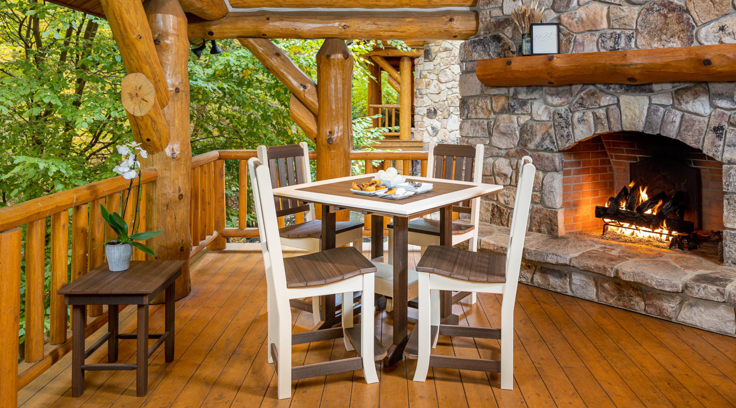 Poly outdoor dining furniture on porch of a log cabin lodge