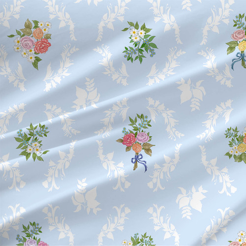 Petaline Ice floral bouquet fabric with pastel roses, daisies, green leaves, and white leafy silhouettes on a pale blue background