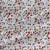 Wild Meadow Original floral fabric with multicolor wildflowers, red, blue, teal, and golden accents, fine stems, and scattered botanical details.