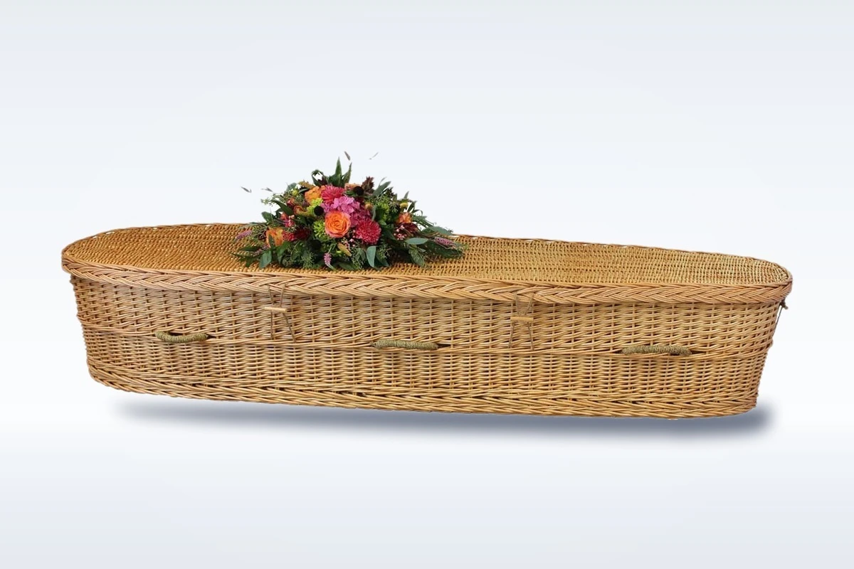 A woven willow casket dressed with flowers