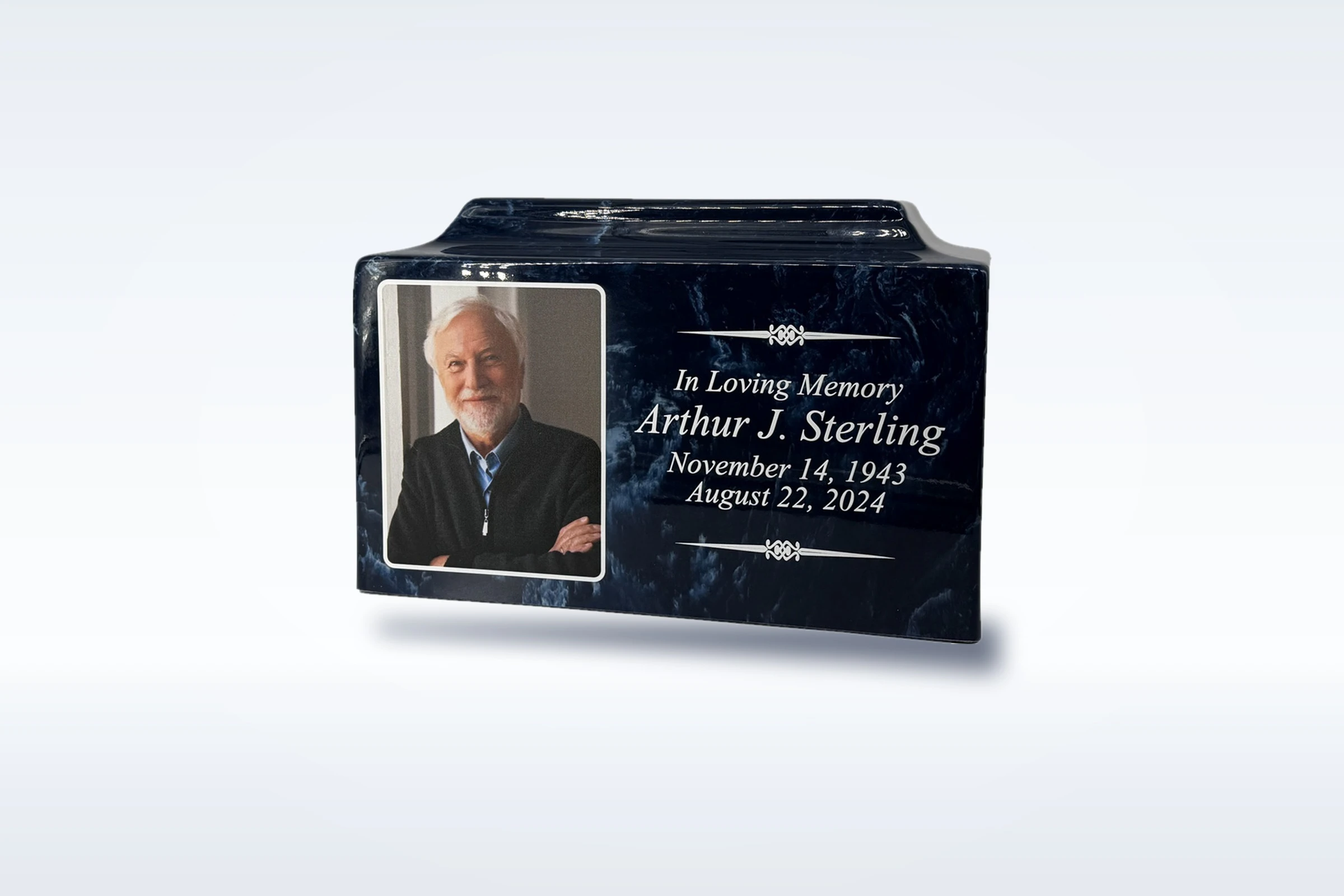 A navy cultured marble photo urn engraved with a portrait, name and dates