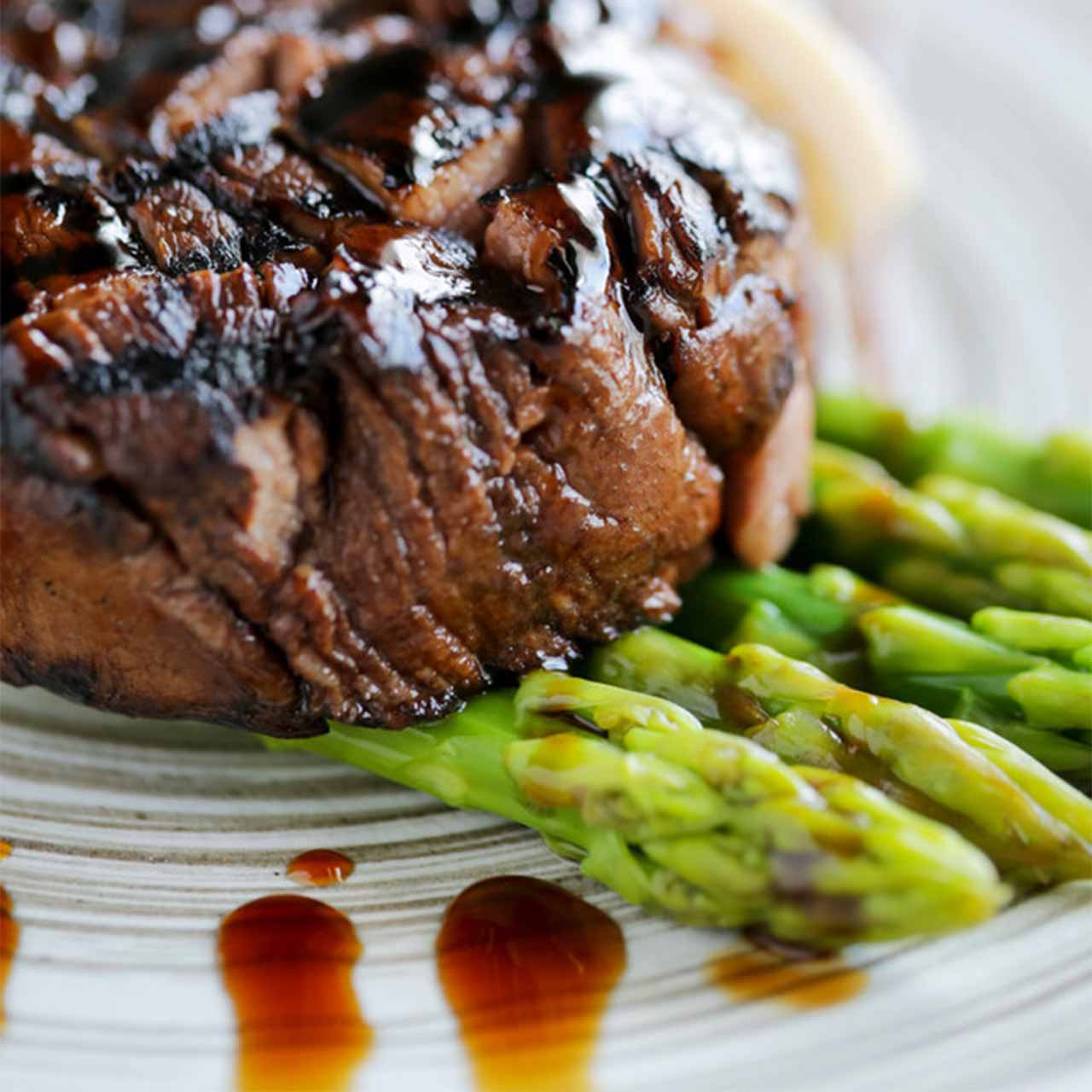 Perfectly seared steak with asparagus, plated elegantly – part of our Romantic Dinner cooking class menu.