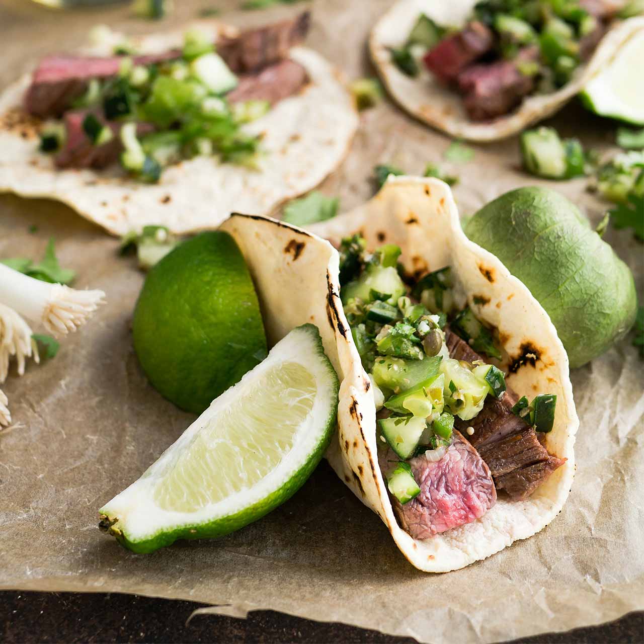 Carne Asada tacos with fresh limes – featured in our Cinco de Mayo cooking class.