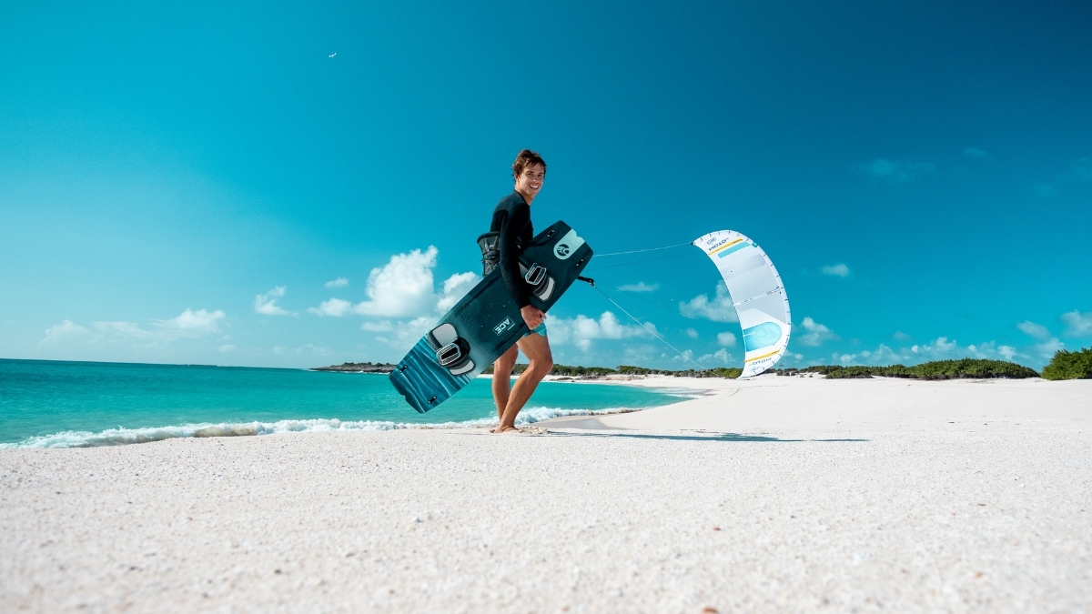 2026 Cabrinha Moto Apex kite and twin tip board on a tropical beach with turquoise water