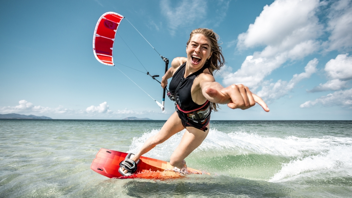 2026 Cabrinha Switchblade Apex kite rider carving on a twin tip board in shallow tropical water