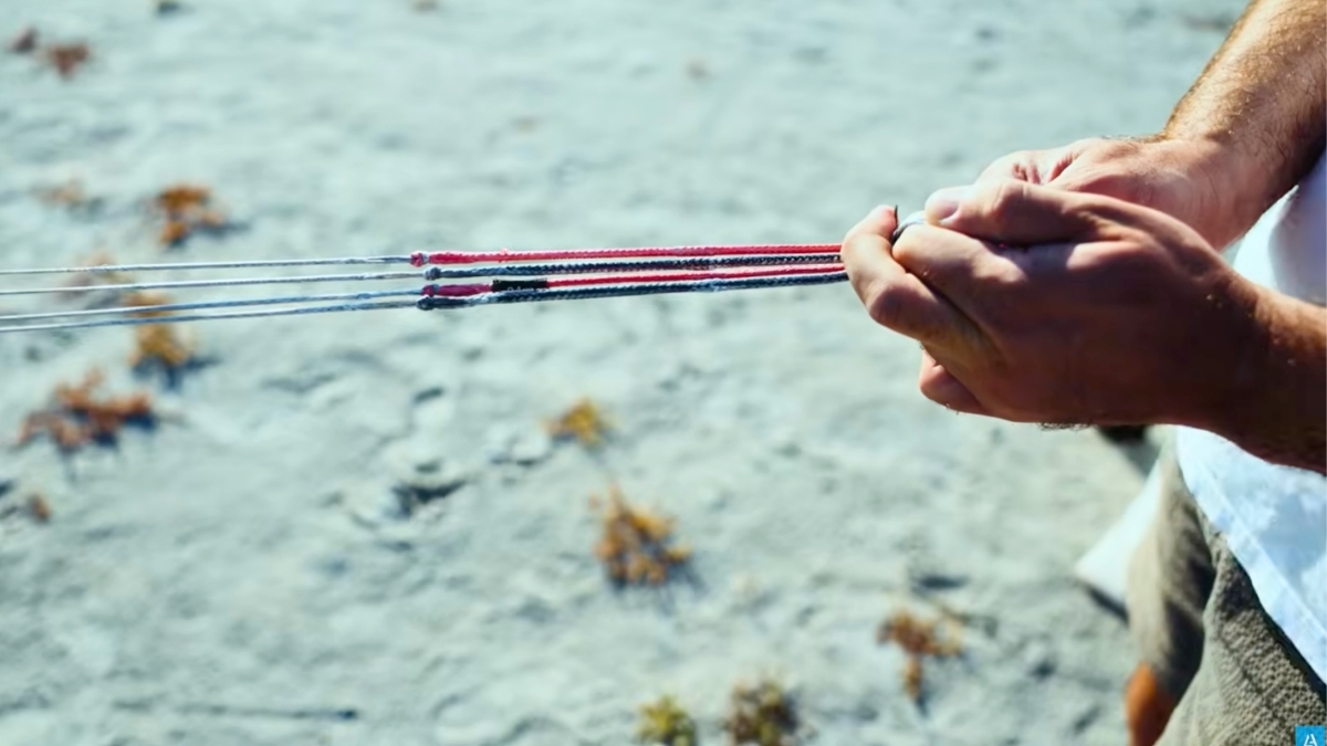 person holding kite lines on the beach