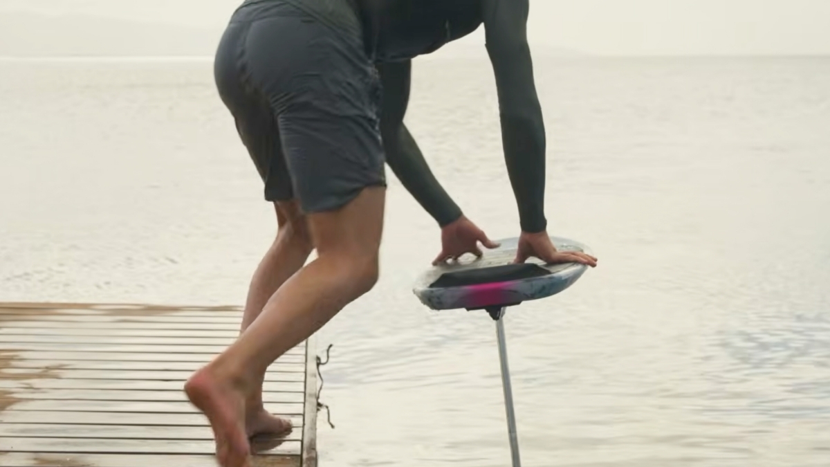 Rider jumping onto a foil board from a dock during a pump foiling dockstart attempt