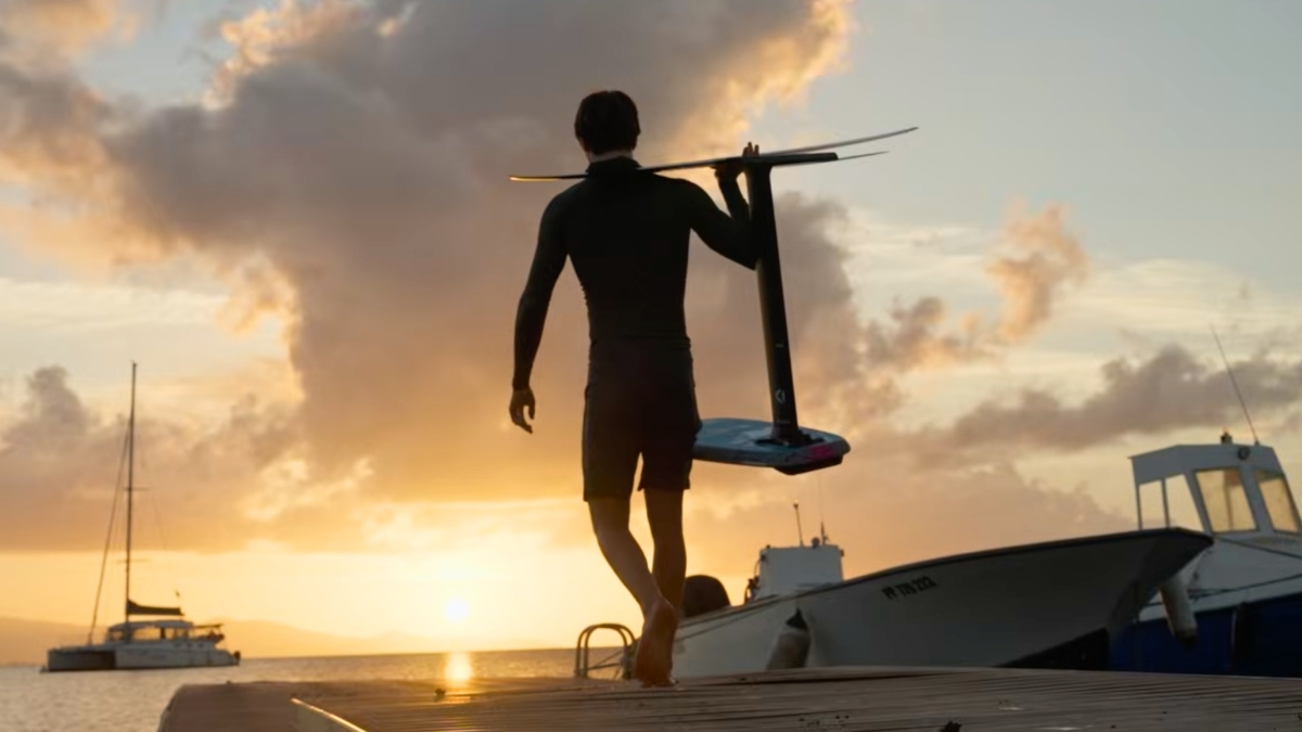 Silhouette of a foil rider on a dock at sunset ready to dockstart