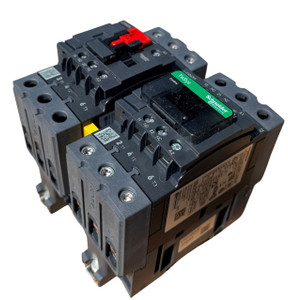 Front perspective view of the Schneider Electric LC2D65AG7 TeSys D 65A reversing contactor assembly, featuring two mechanically interlocked contactors with screw terminals and TeSys branding.