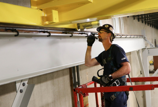 Overhead crane technician inspecting a crane