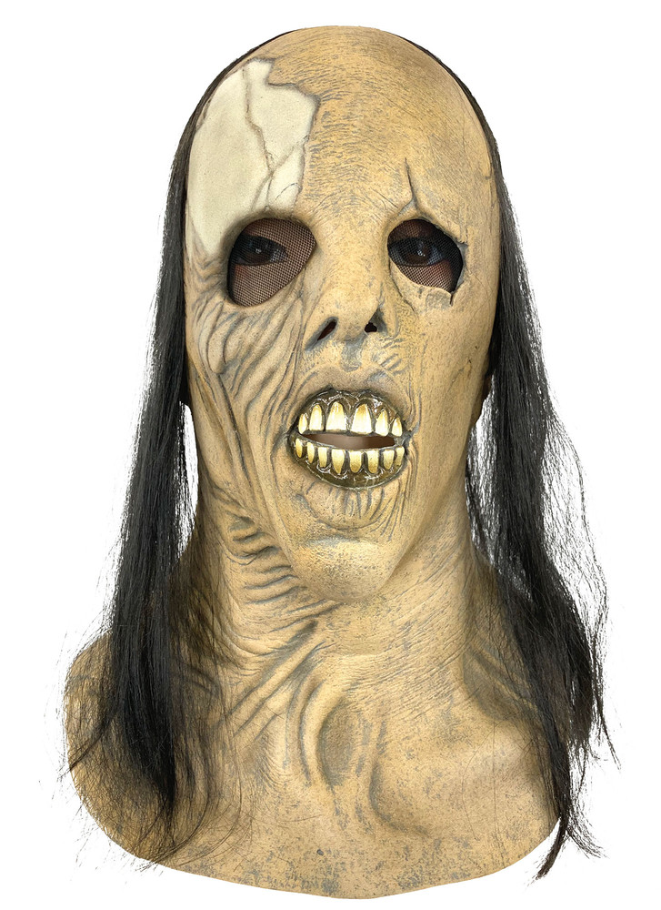 Full-head latex horror mask with wrinkled decayed skin, yellowed exposed teeth, and long straight black hair on a white ba…