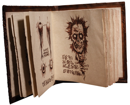 Open replica Necronomicon prop book showing aged pages with hand-drawn zombie skull and eye illustrations with fictional r…