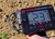 Close-up of a person using the XP ICON metal detector control screen while detecting outdoors.