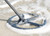 XP ICON-X metal detector search coil sweeping through shallow surf at the beach.