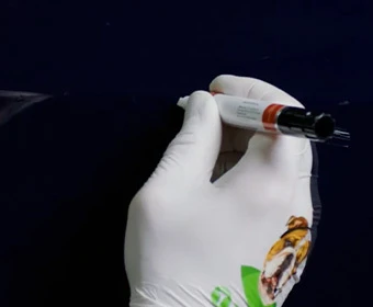 Gloved hand applying clearcoat with a TouchUpDirect pen over a repaired paint chip