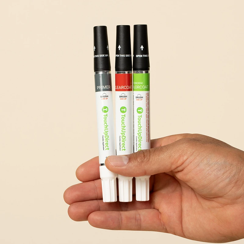 Hand holding several touch up combo applicators.