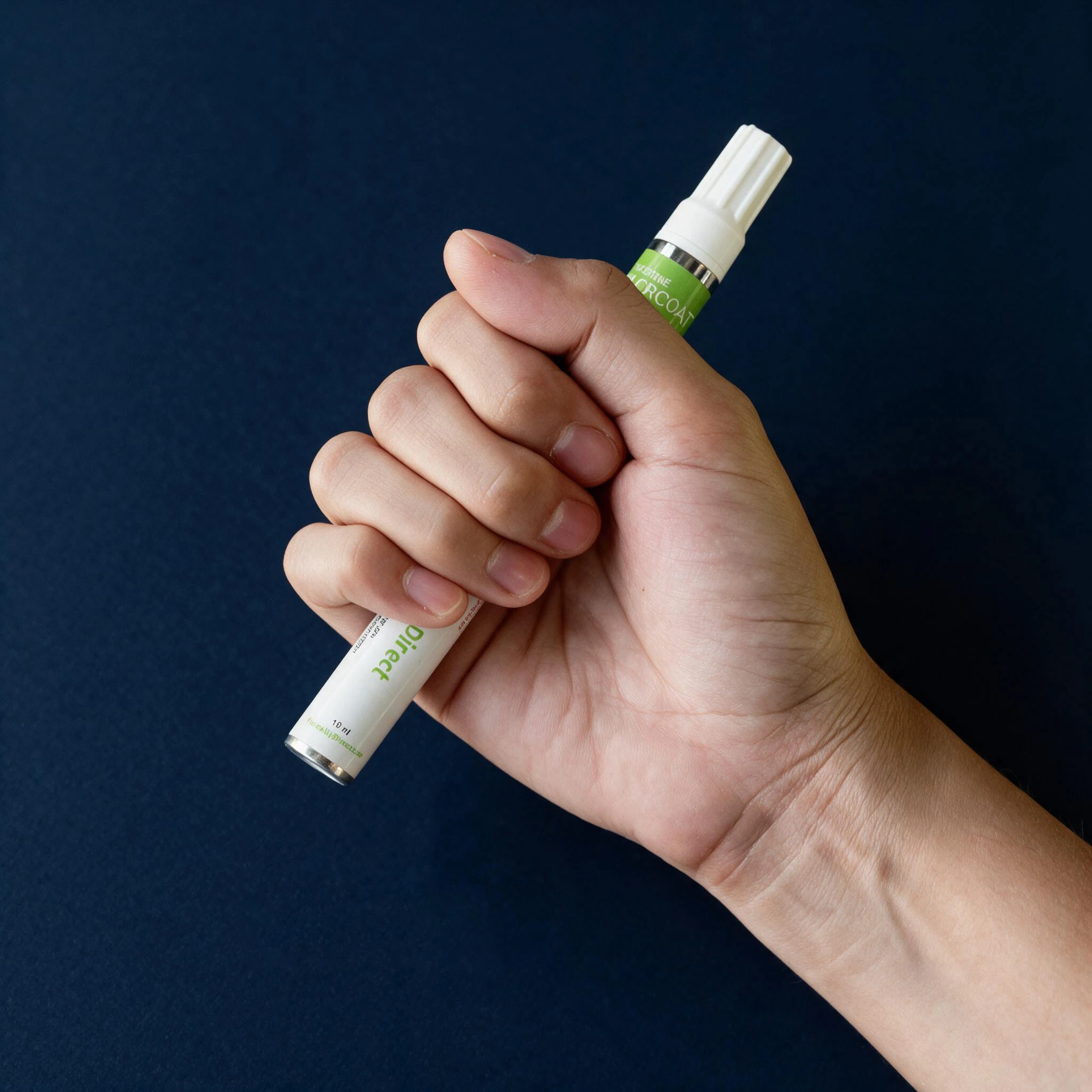 Hand holding a TouchUpDirect paint pen before shaking and mixing the paint