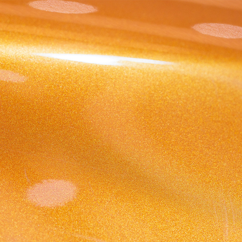 Close-up of metallic pearl automotive paint reflecting light at different angles.