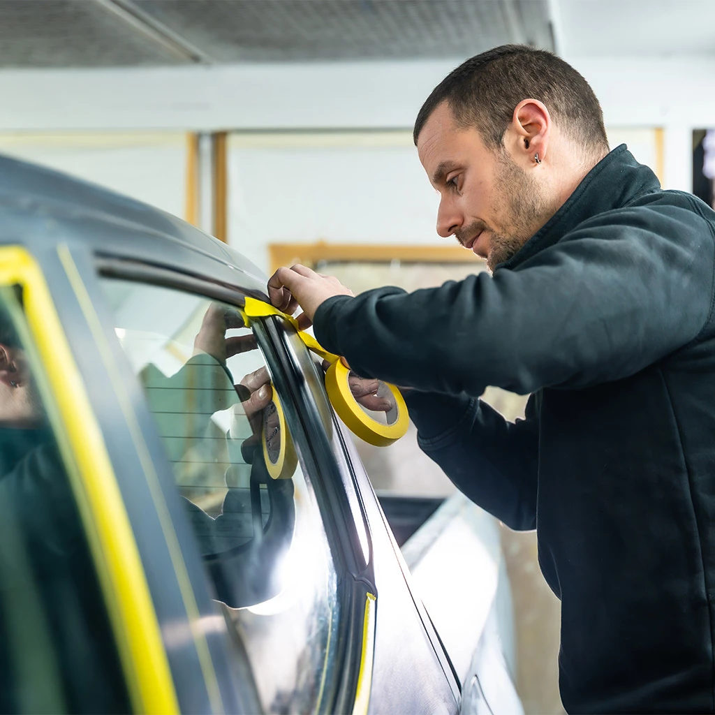 Person preparing to paint a vehicle in a clean and well-ventilated workspace