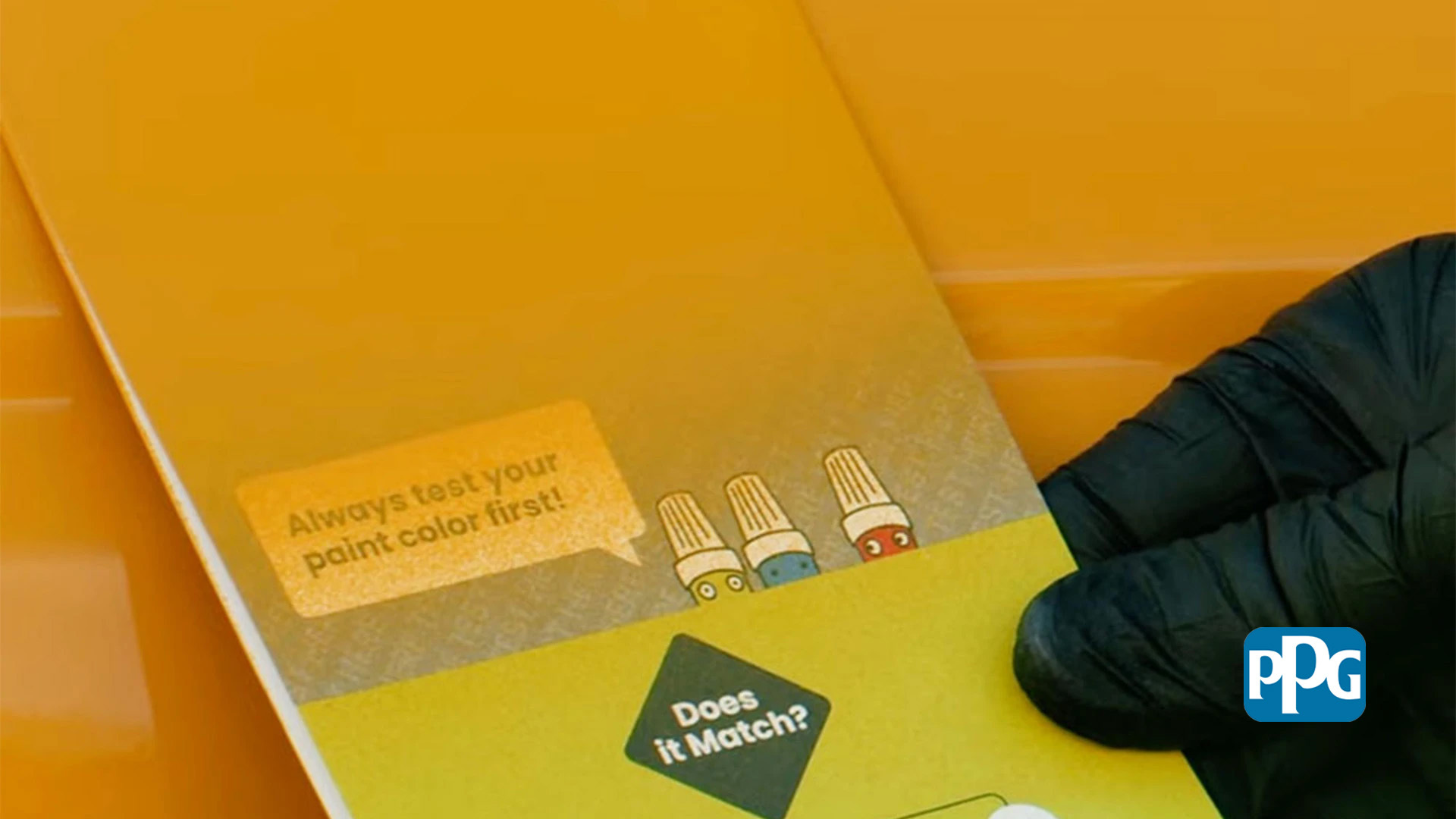 Gloved hand comparing a painted test card with an orange vehicle panel.