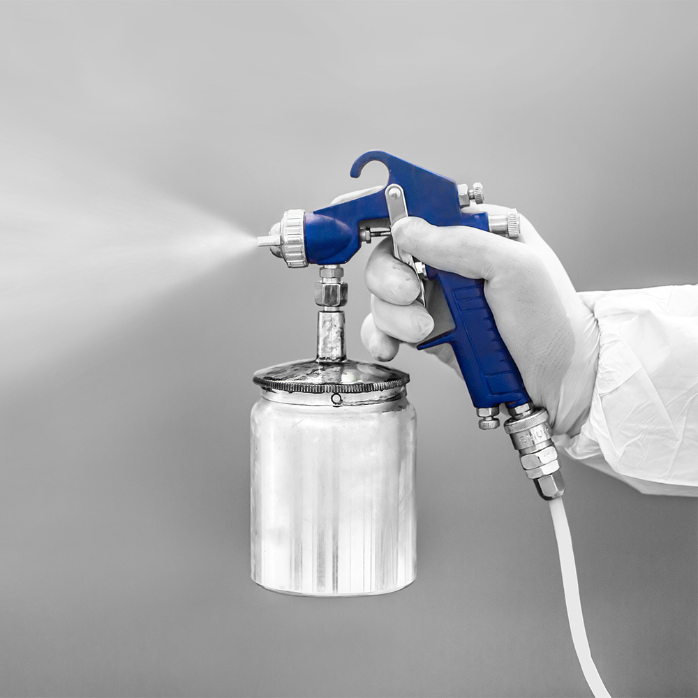 Automotive paint spray gun connected to a paint cup