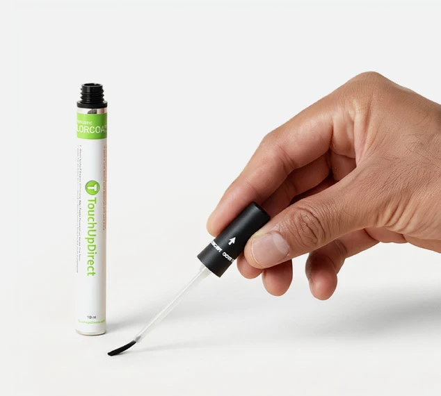 Hand using a TouchUpDirect paint brush to repair an automotive scratch