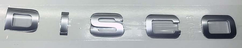 LR063639 - Front Lettering for Discovery Sport - Spells Out D I S C O - In Atlas Grey - Genuine Land Rover Image 1