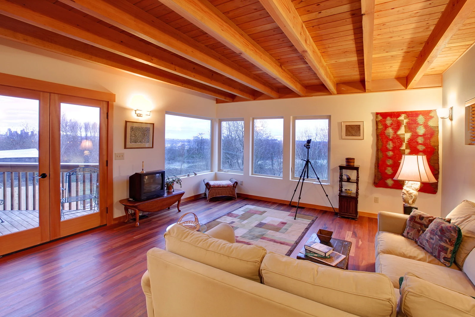 Living room with a tongue and groove wood ceiling, exposed beams, and coordinating wood trim