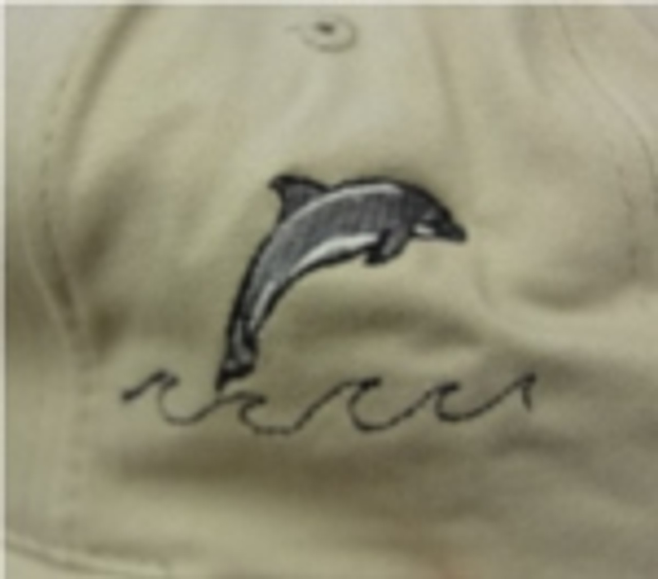 the tan hat has embroidered lettering on the back and a dolphin on the side