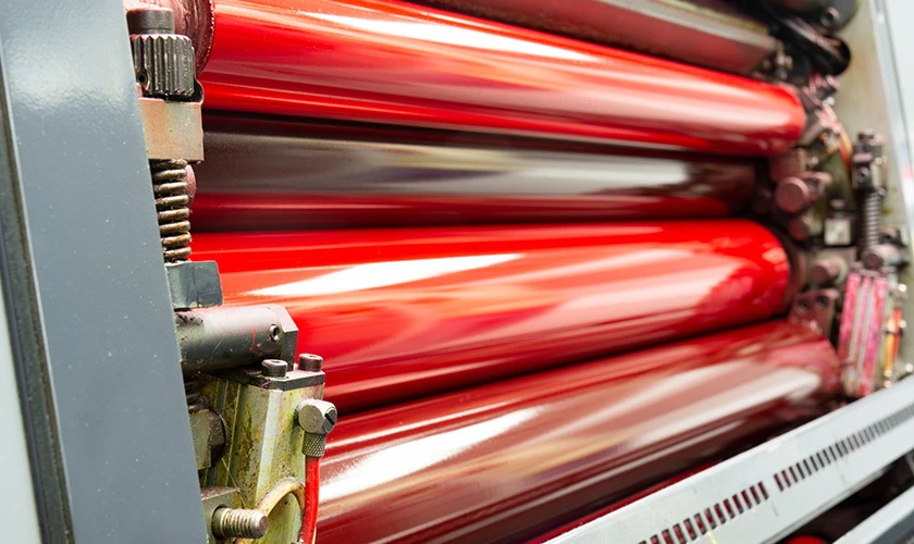 industrial cylinders on a printing press, visible ink on the surface of the offset printing process