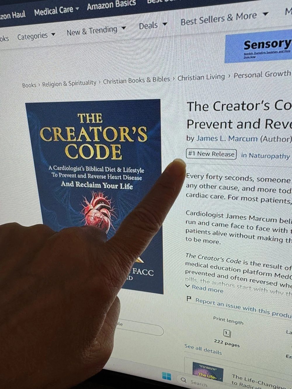 A finger pointing to The Creator's Code on Amazon, marked #1 New Release in Naturopathy