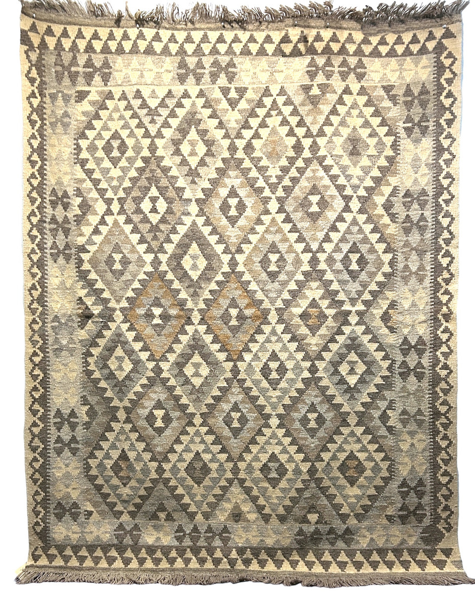 Handwoven wool Kilim rug from Turkmen artisans of Afghanistan. These rugs are a traditional technique with geometric designs and are durable and reversible. With a 'no-waste' approach to weaving, the women incorporate pieces of yarn scraps from other weaving work to create these rugs.  Since the Taliban took control of the country, rug weaving and farming are the only means rural women have to earn an income. This collection comes to us from the same group as the Turkmen felted rugs and we feel honored to represent these talented and hard working weavers. Colors: natural wool fleece colors- cream, camel, light grey, medium grey, taupe and dark grey.