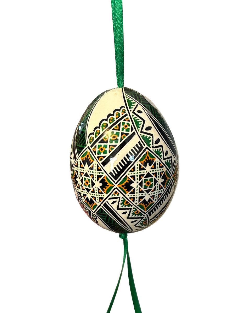 Direct from Ukrainian Folk Artist Lesia Pona- Pysanka/Ukrainian Easter Eggs. Ukrainians have been decoration eggs creating these small jewels for many generations. Archeologists have discovered ceramic Pysanky in Ukraine dating back to 1300 B.C. The symbolism comes from the ancient Trypillian culture. For Ukrainians, the Pysanka brings good fortune, wealth, health and protection to the home. We are selling these to help support Lesia during these terrible times in Ukraine. Each egg is one-of-a-kind. Colors: pine green, golden orange, black and white.

