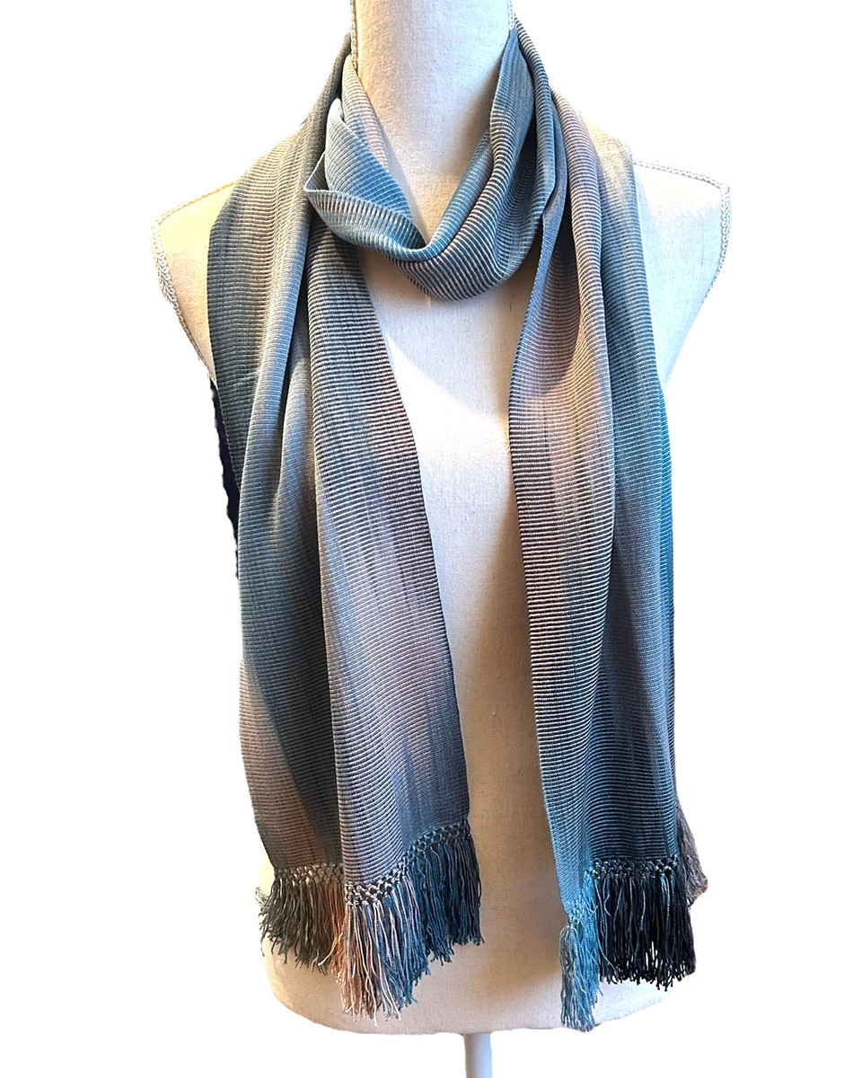 Handwoven bamboo scarf dyed and woven by hand by a women's cooperative. The colors are spaced dyed giving a beautiful effect of soft, flowing, changing colors. Light weight with a very soft feel. A cascade of color- pale blues, silver pink, and charcoal. 
