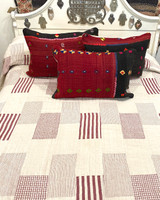 Handwoven Organic Cotton Patchwork Hand Stitched Queen Quilt India. his patchwork quilt has 4 different striped patterns in chalky red and natural white, and solid natural white blocks There are rows of white hand stitching one inch apart. The back is solid off-white natural cotton. It is two layers with a lightweight cotton batting inside. 