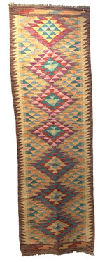 Handwoven wool Kilim rug from Turkmen artisans of Afghanistan. These rugs are a traditional technique with geometric designs and are durable and reversible. With a 'no-waste' approach to weaving, the women incorporate pieces of yarn scraps from other weaving work to create these rugs.  Since the Taliban took control of the country, rug weaving and farming are the only means rural women have to earn an income. This collection comes to us from the same group as the Turkmen felted rugs and we feel honored to represent these talented and hard working weavers. Colors: wheat, and variageted tones of turquoise, sky blue, red brick, pumpkin,  chalky greens, purple, lavender and uchre. Great long runner rug.