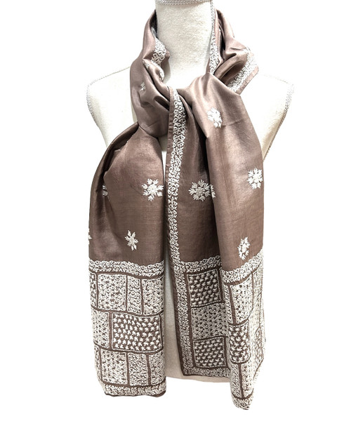 Very fine hand spun and hand woven silk scarf from a group in Bangladesh. The scarf front is hand stitched with a fine overall pattern. The scarf is then lined so the back of the stitching is not showing. The silk is a beautiful soft cocoa with white stitching. 