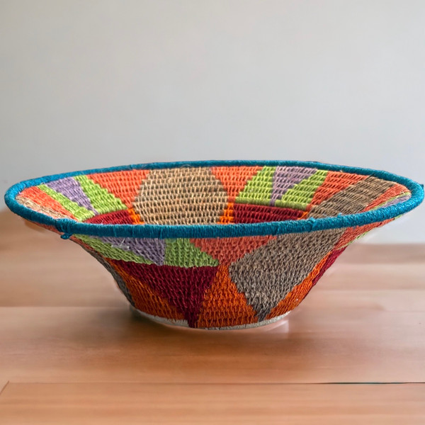 Handwoven medium size fiber basket made with natural sisal from sustainably harvested sources. This is from a small artisan organization that has been working in Eswatini (Swaziland) since 1985. Very sturdy. Beautiful on the table or on the wall. Colors:papaya, lime green, deep red, cocoa, lavender and cream.

