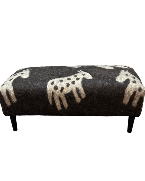 A beautiful bench made with dense hand felted wool. Made by a Trukmen artisans in Afghanistan. The design is horses in natural wool colors of charcoal and natural. Great for at the foot of the bed or in any seating area.