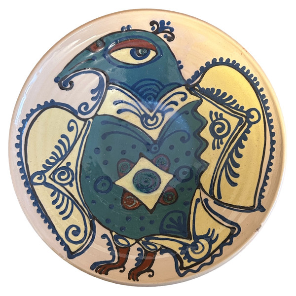 Handmade earthenware platter by Ivan Bobkob. Ivan's food-safe pottery is decorated with bird imagery, a triumphant symbol for Ukrainians representing freedom, rebellion and determination.  Ivan’s pots are painted with birds and Ornek ornamentation, a system of specific symbols embedded with meaning and used by the Crimean Tartar communities. Ornek ornamentation is applied to wood working, weaving, pottery glass, wall paintings and jewelry. (Ornek ornamentation has been placed on the National List of Elements of the Intangible Cultural Heritage of Ukraine.) The cream colored plate has a whimsical bird. Colors: pale yellow, chalky teal, Prussian blue, brick and charcoal. 

