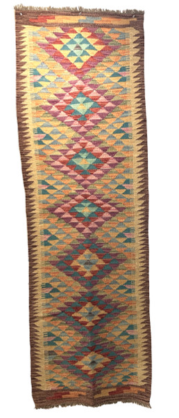 Handwoven wool Kilim rug from Turkmen artisans of Afghanistan. These rugs are a traditional technique with geometric designs and are durable and reversible. With a 'no-waste' approach to weaving, the women incorporate pieces of yarn scraps from other weaving work to create these rugs.  Since the Taliban took control of the country, rug weaving and farming are the only means rural women have to earn an income. This collection comes to us from the same group as the Turkmen felted rugs and we feel honored to represent these talented and hard working weavers. Colors: wheat, and variageted tones of turquoise, sky blue, red brick, pumpkin,  chalky greens, purple, lavender and uchre. Great long runner rug.