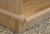 Bottom corner detail shows the solid oak edge banding and the trim that hides the six dual wheel casters. Narrow Tv stand with Glass Doors 33" High shown in natural oak satin finish.  https:// decibeldesigns.com 805.331.8506