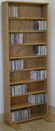 DVD shelves 60" high shown in light brown oak. 8 adjustable shelves. wall mountable.Feet can be removed. All formaldehyde free cabinet plywood construction. No particle board. A real quality cabinet. decibeldesigns.com 888.850.5589