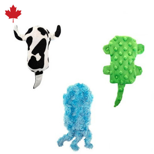 Three Senseez Soothables handheld vibrating massagers displayed together. Left: black and white cow with tail. Center: blue fuzzy jellyfish with tentacles. Right: green turtle with textured bumps. All feature soft plush construction. Canadian product with maple leaf icon shown above.