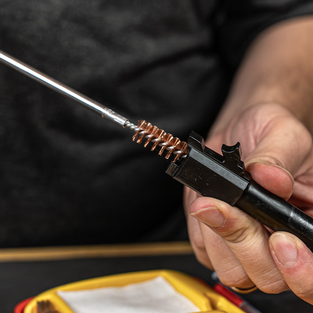 Lifestyle image of image of Shooter's Choice .40 caliber Pistol Cleaning Kit rod and bore brush shown in use